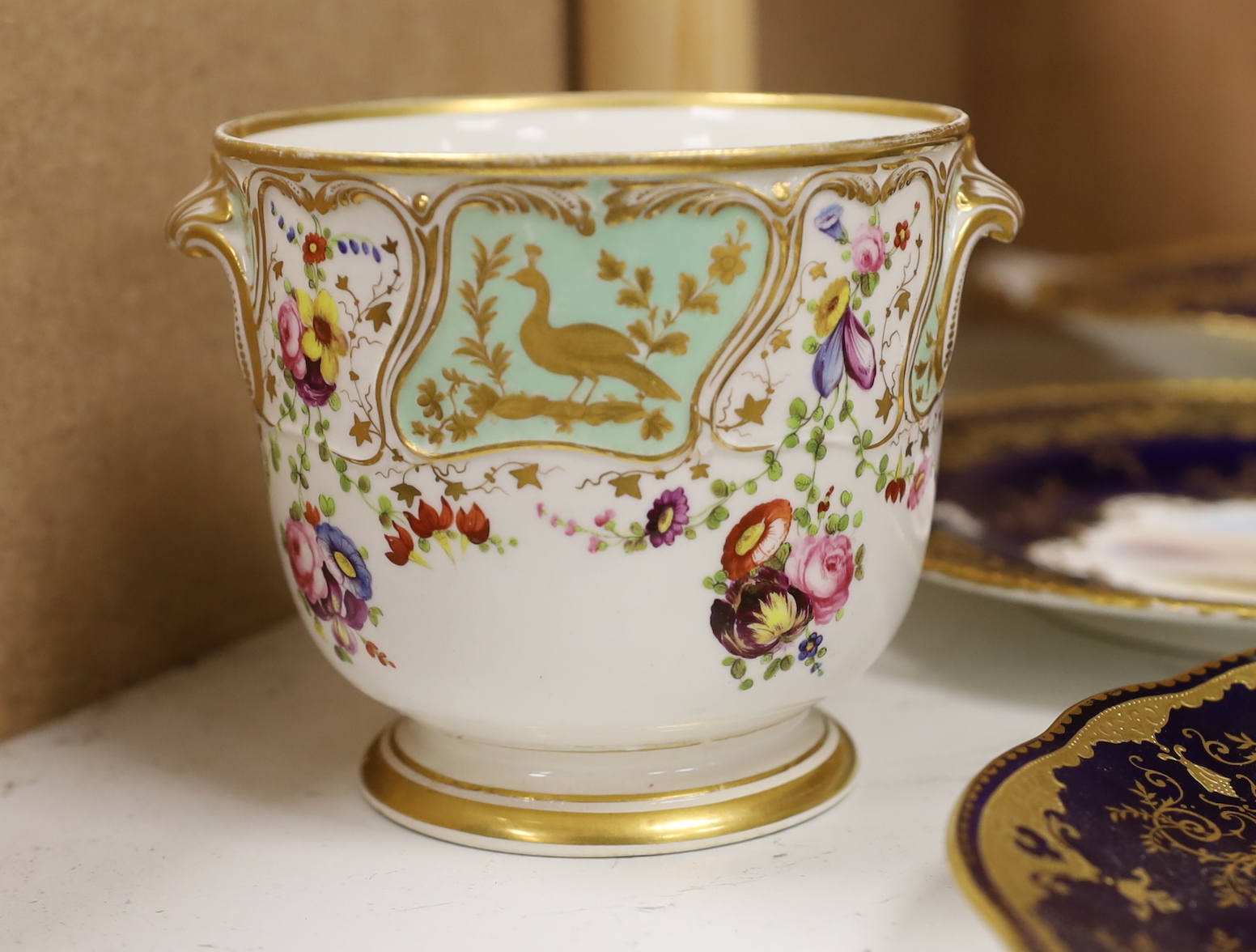 Four 19th century Coalport plates, a Coalport dish, a Minton plate, a Coalport inkstand in Chelsea style and a Derby cache pot, ink stand 40cms wide
